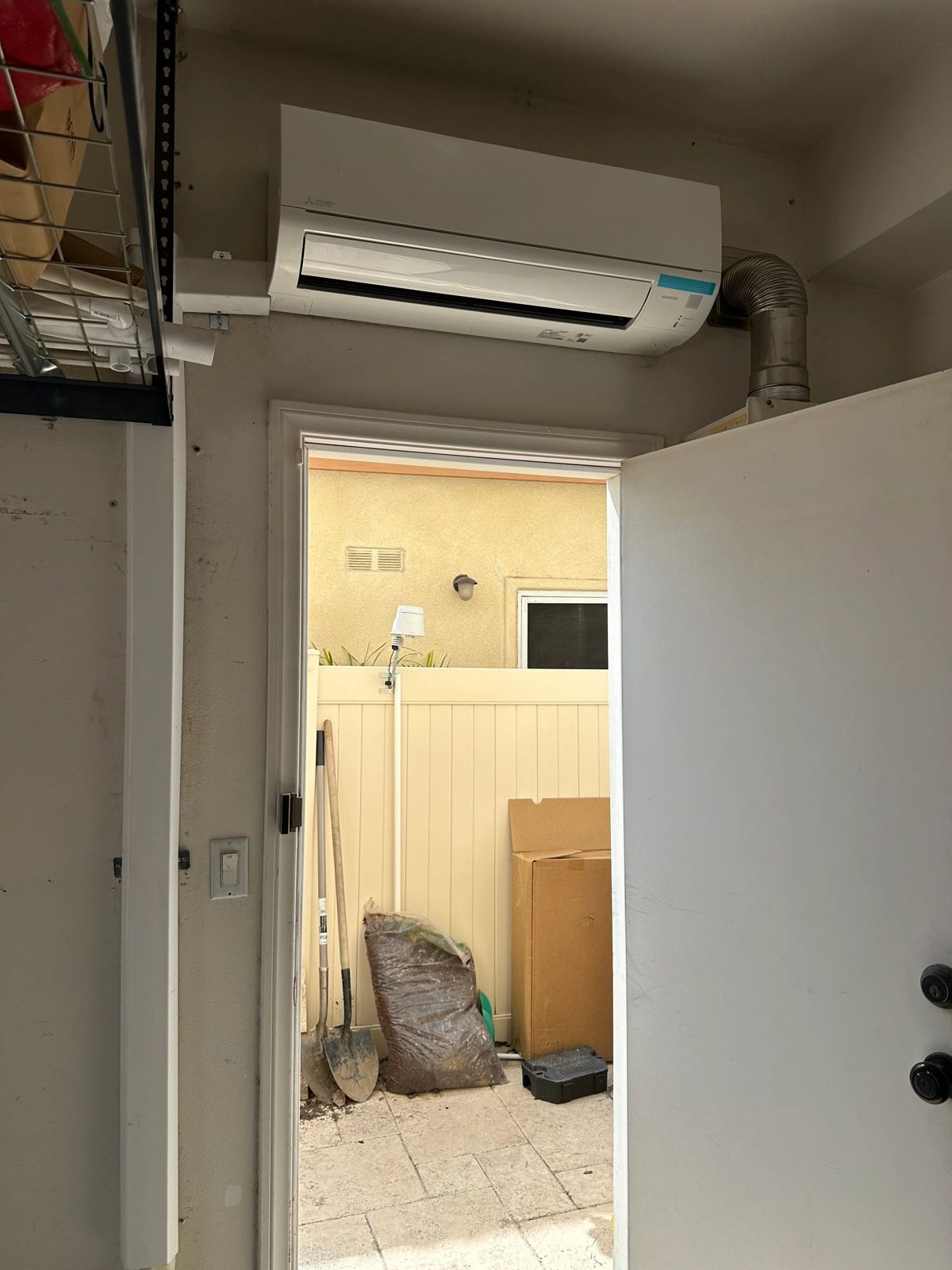 Technician installing 1.5 Ton Mitsubishi mini-split outdoor unit