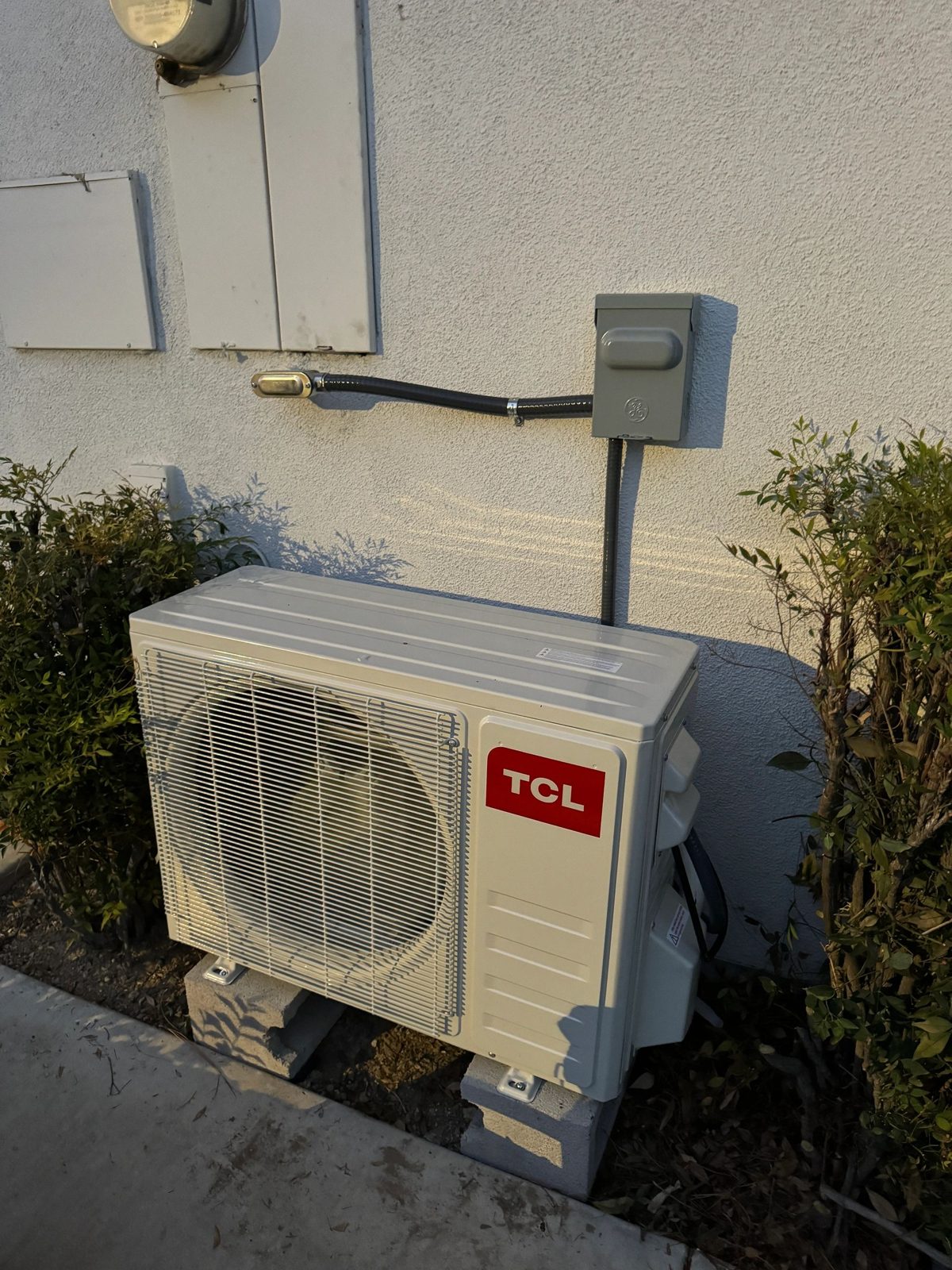 Technician installing 1.5 Ton TCL mini-split indoor unit on wall