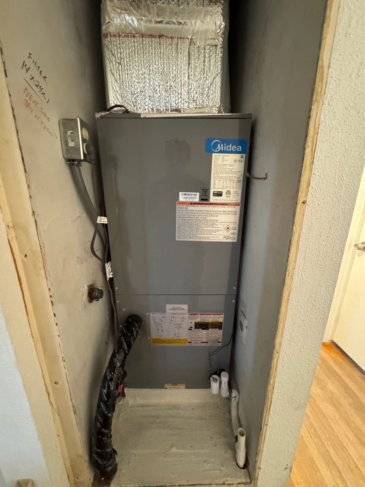 Technician installing 3 ton Midea heat pump outdoor unit