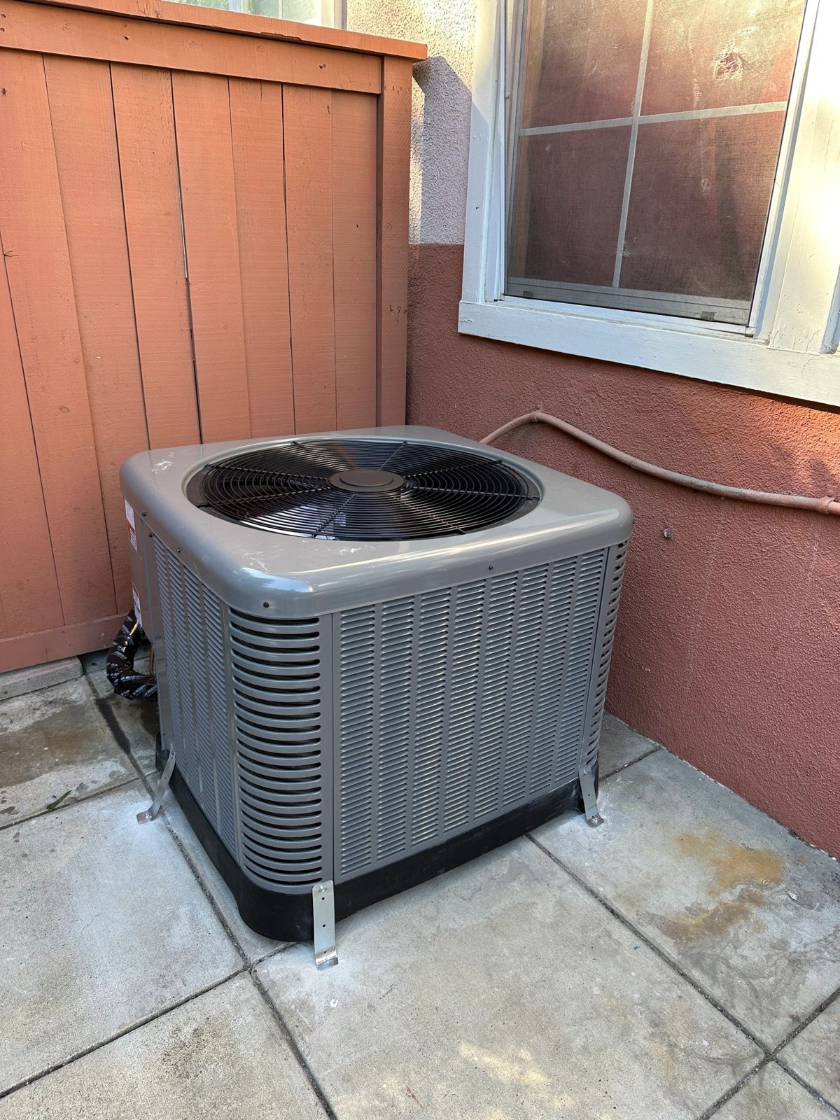 Technician installing a 3-ton Rheem heat pump outdoor unit