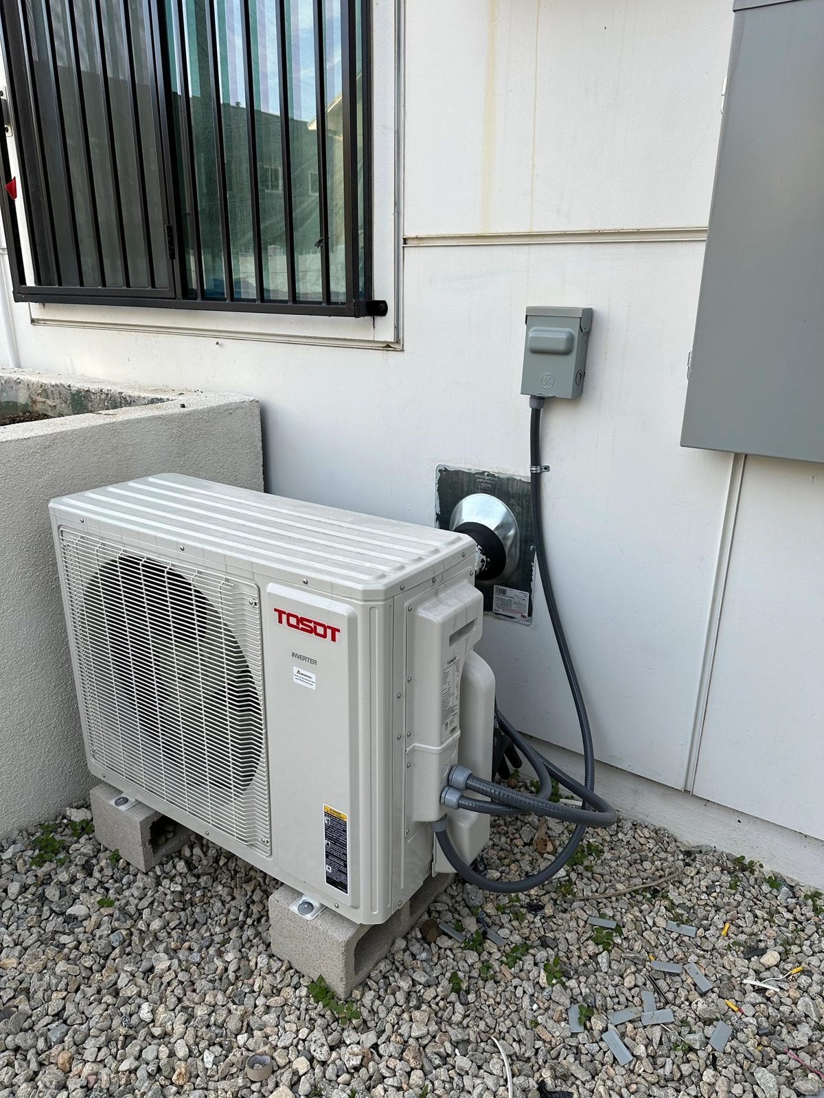 Outdoor TOSOT inverter mini-split heat pump unit on gravel