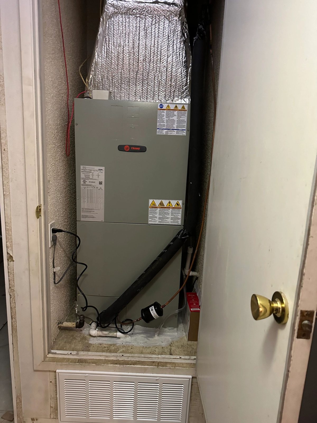 Technician installing Trane 3-ton heat pump outdoor unit