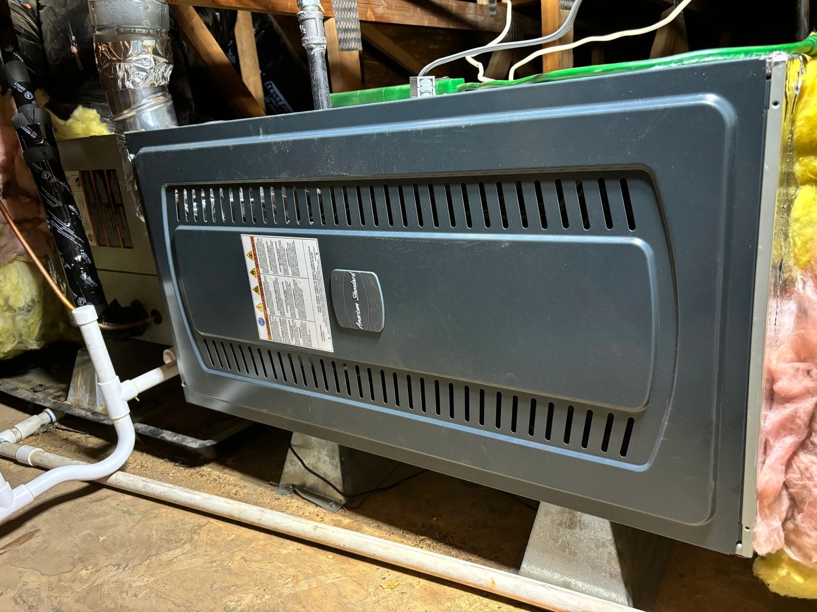 Technicians installing a 4-ton American Standard HVAC unit on a residential rooftop