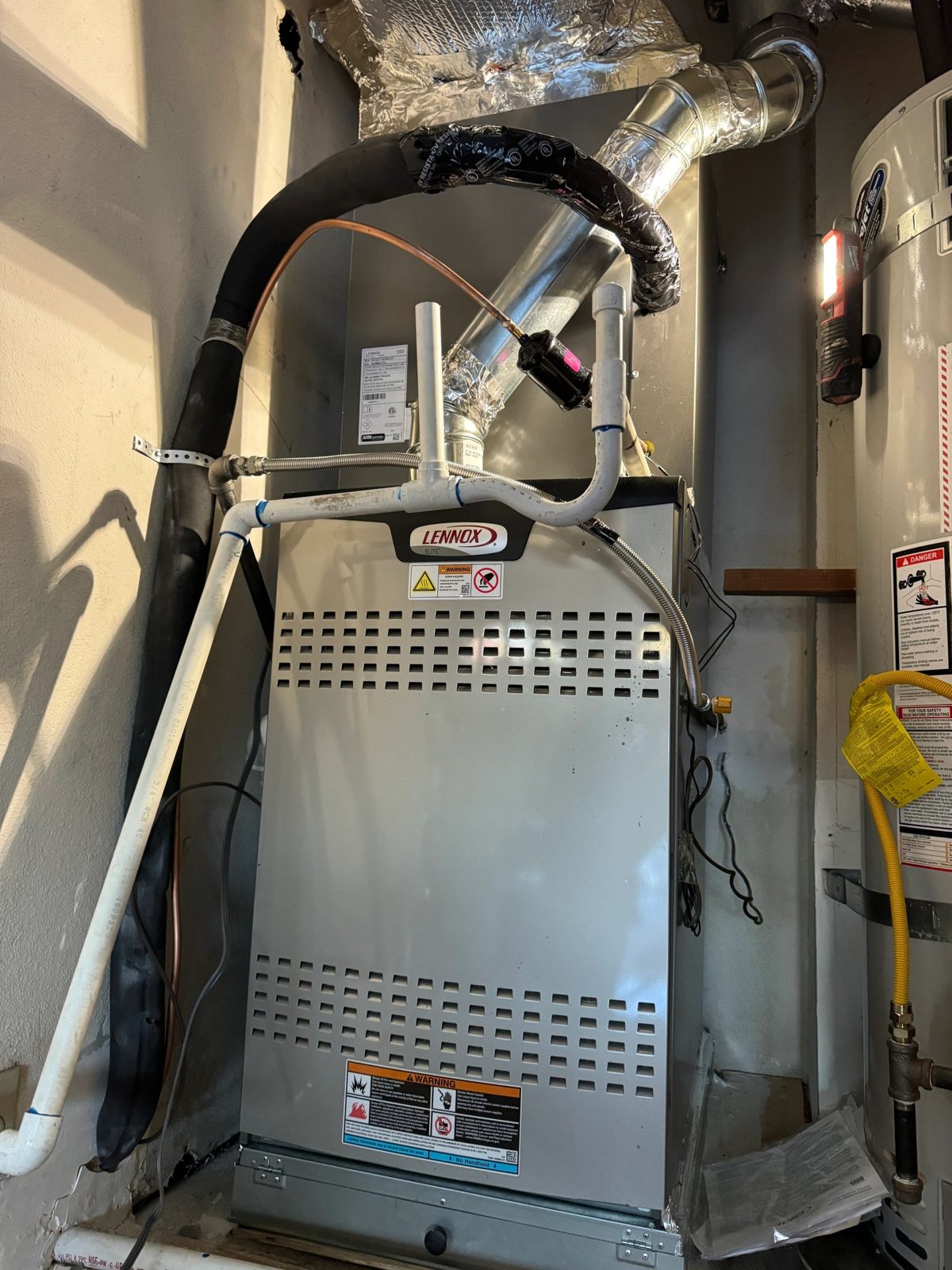 Lennox Elite furnace with pipes and water heater nearby