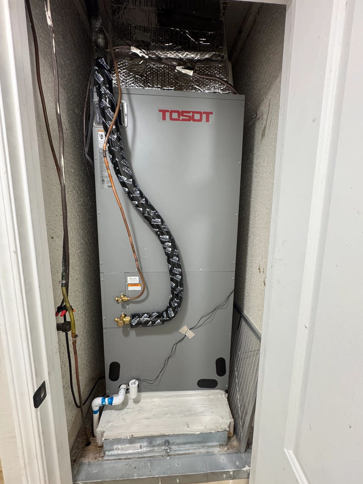 Technicians installing a 5 Ton Tosot Inverter Heat Pump outdoor unit