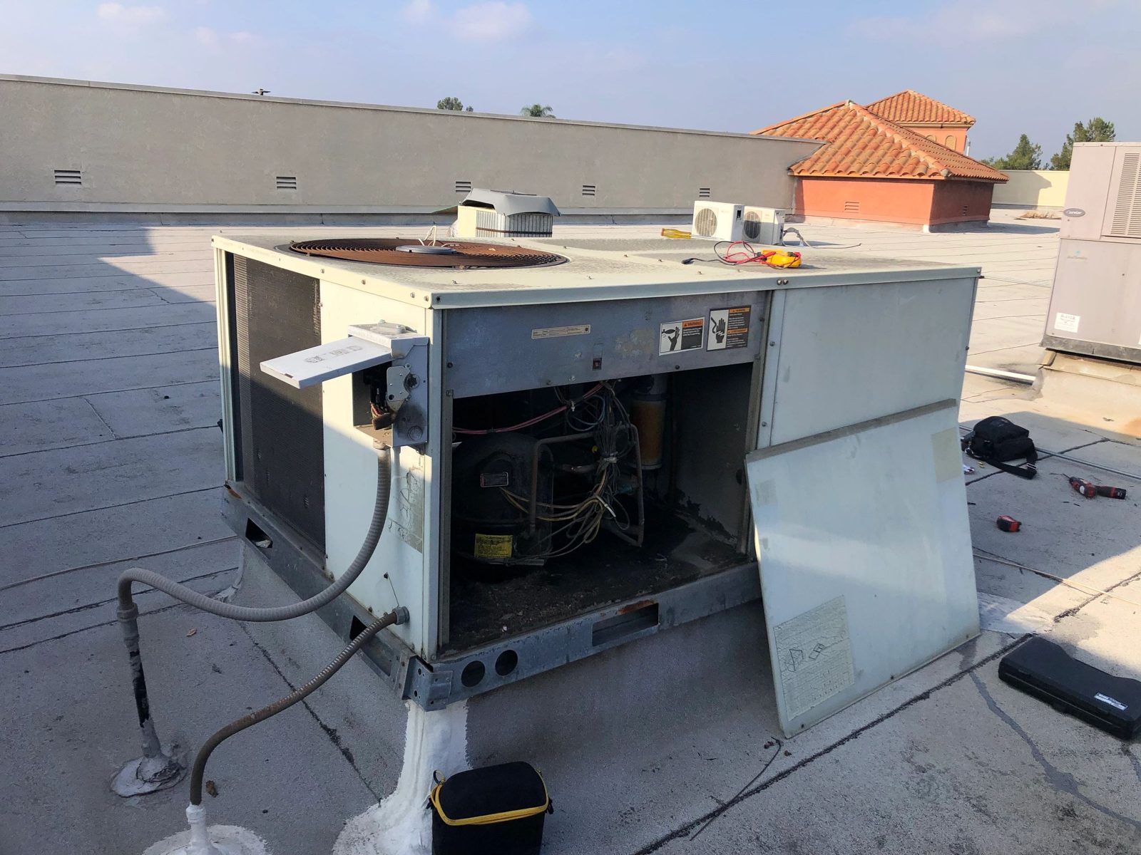HVAC technician conducting air balance test on rooftop commercial package unit