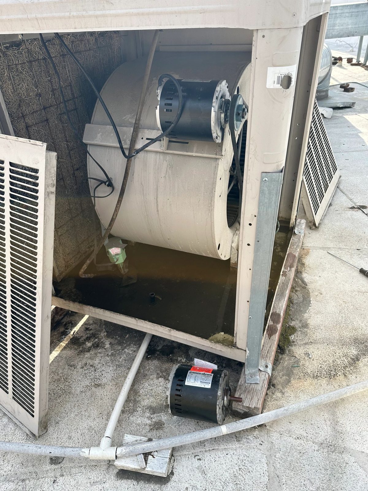 Technician inspecting evaporative cooler unit on rooftop
