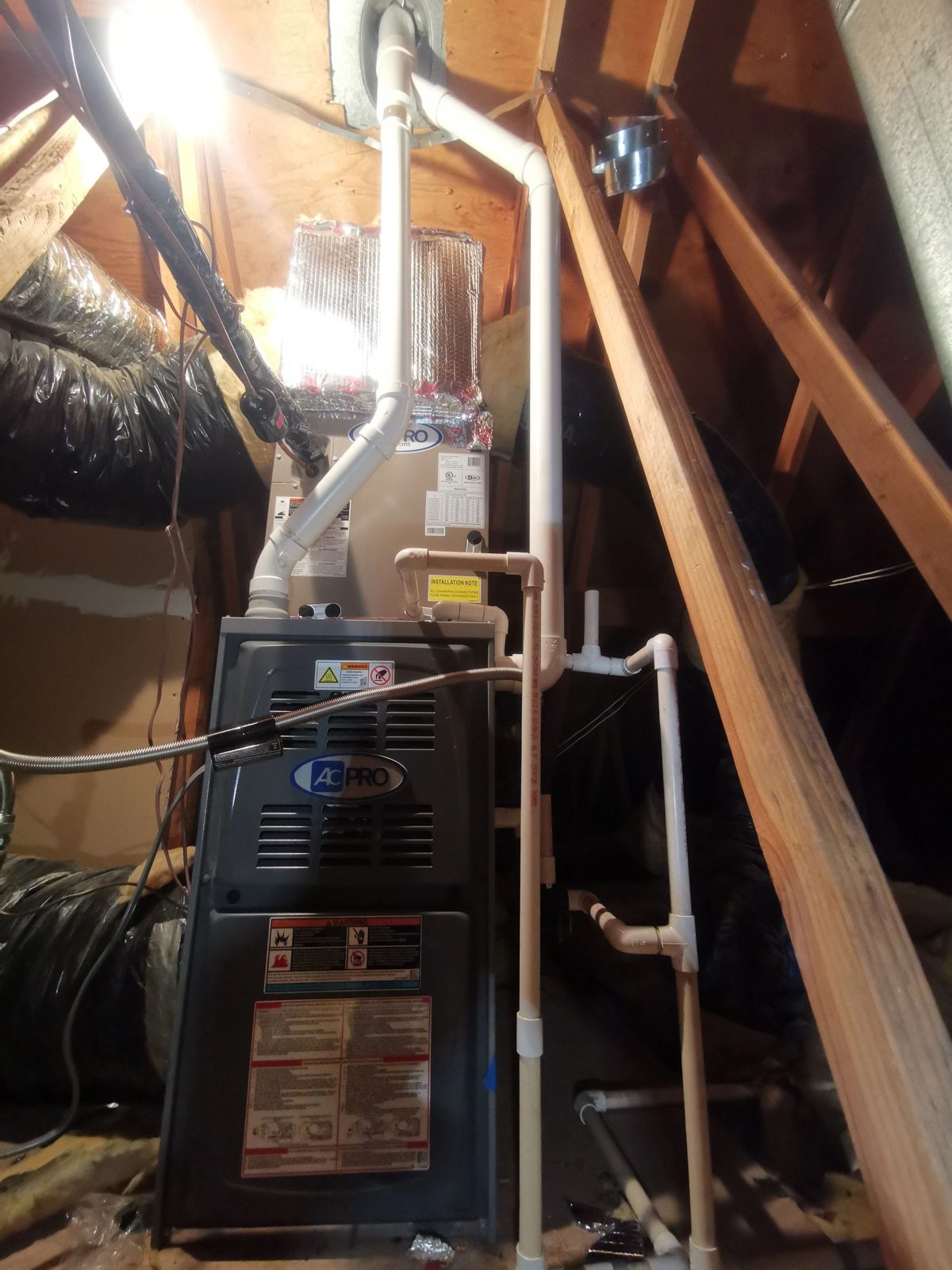 Technician installing a high efficiency furnace in a residential utility space