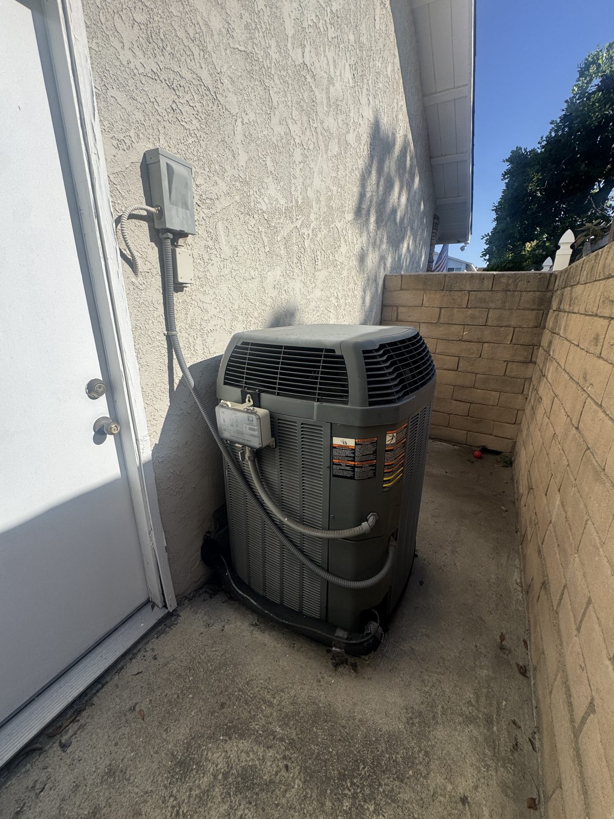Outdoor HVAC condenser unit by wall in Chino Hills after repair service