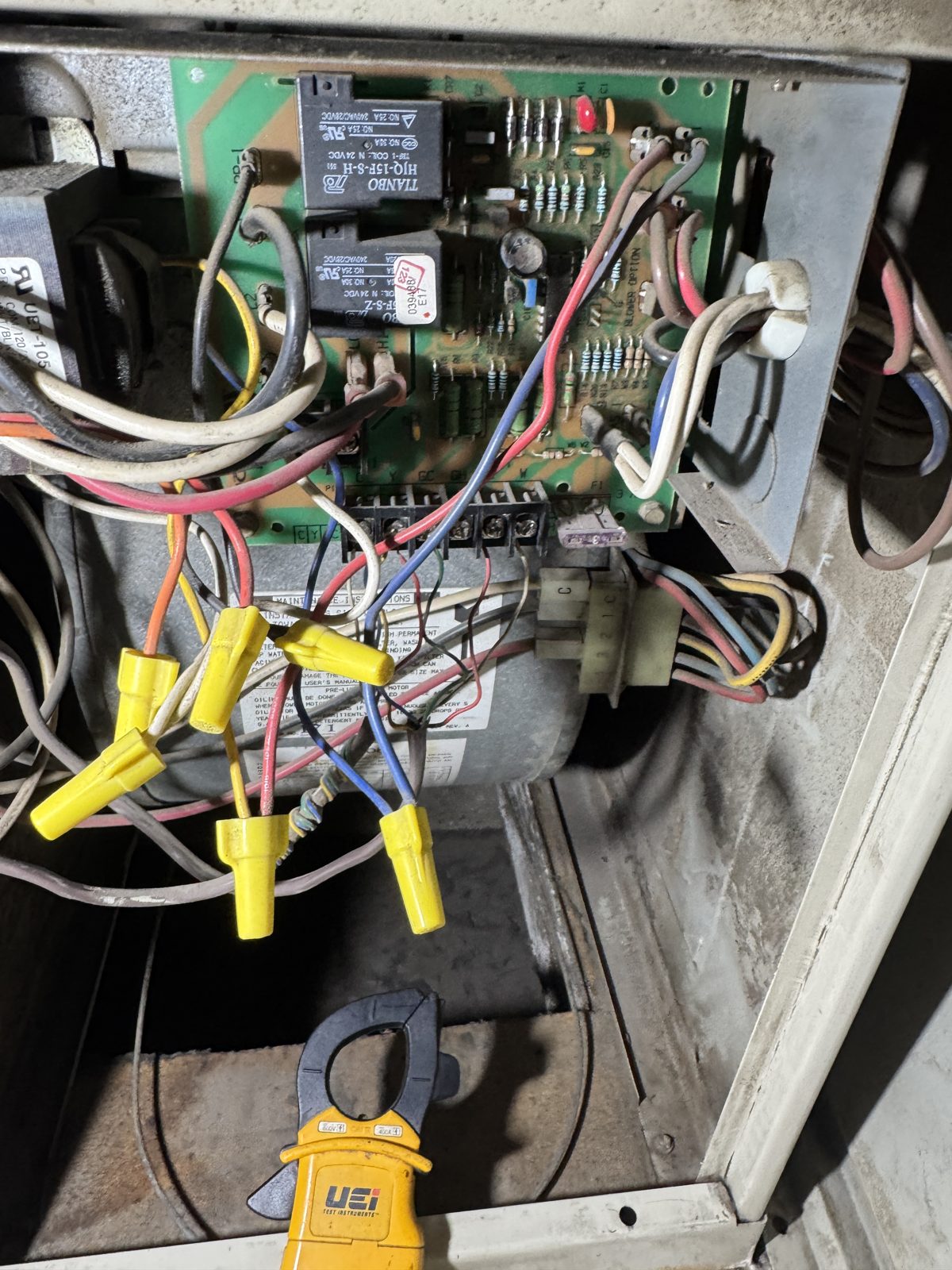 Open HVAC panel with circuit board, relays, wires and clamp meter next to thermal camera view of ceiling air vents and Honeywell thermostat showing 81F