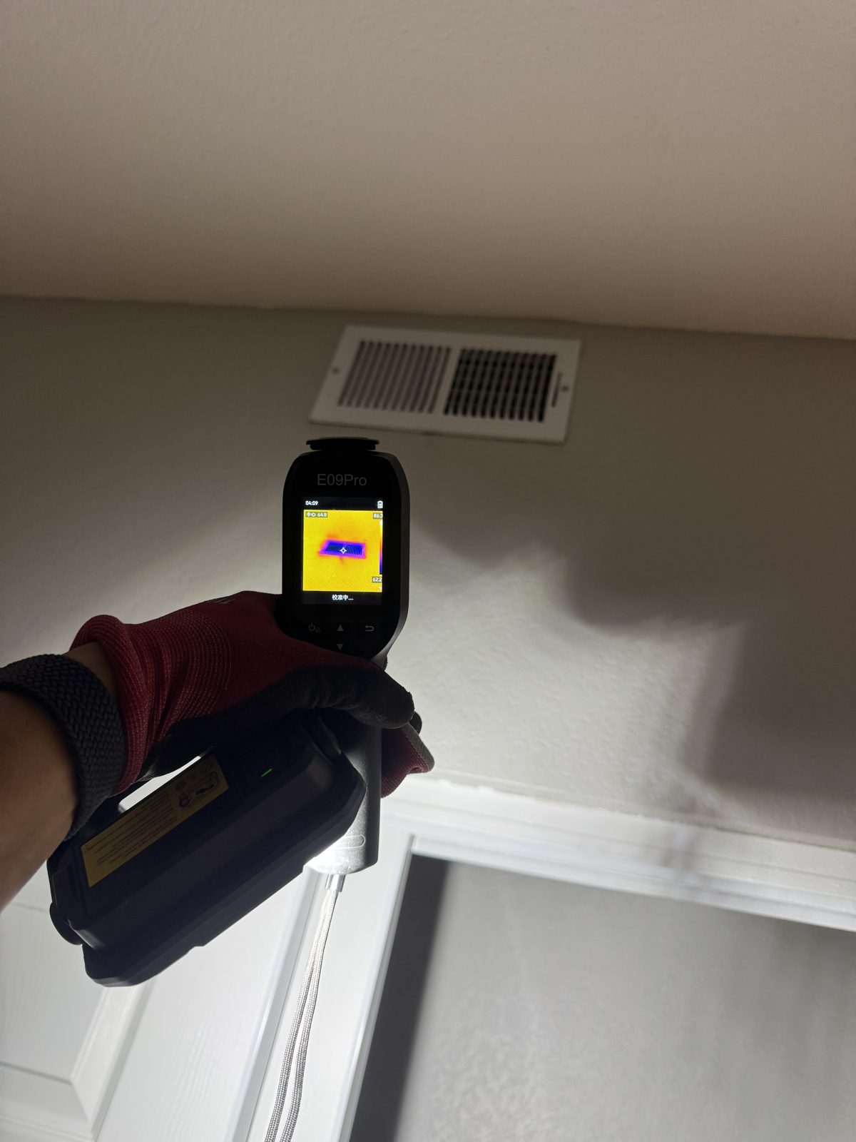 Technician performing HVAC repair in Eastvale with thermal camera, new Honeywell thermostat, and old capacitor
