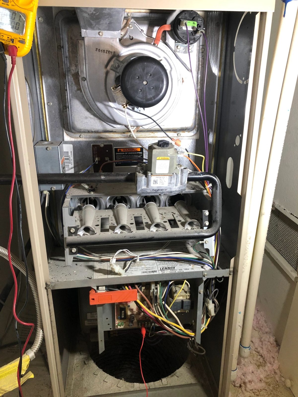 Technician replacing inducer fan motor on residential furnace
