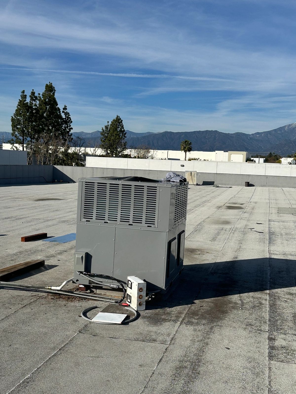 Gray packaged rooftop HVAC unit on flat commercial roof
