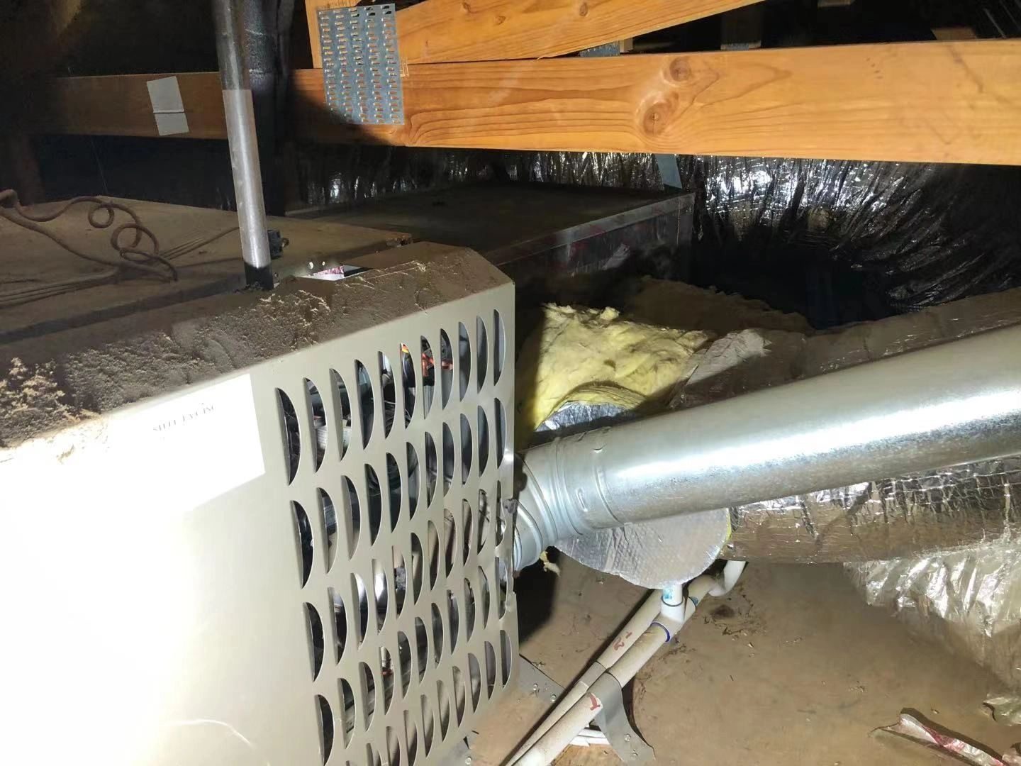Gray HVAC furnace with vent pipe in unfinished attic