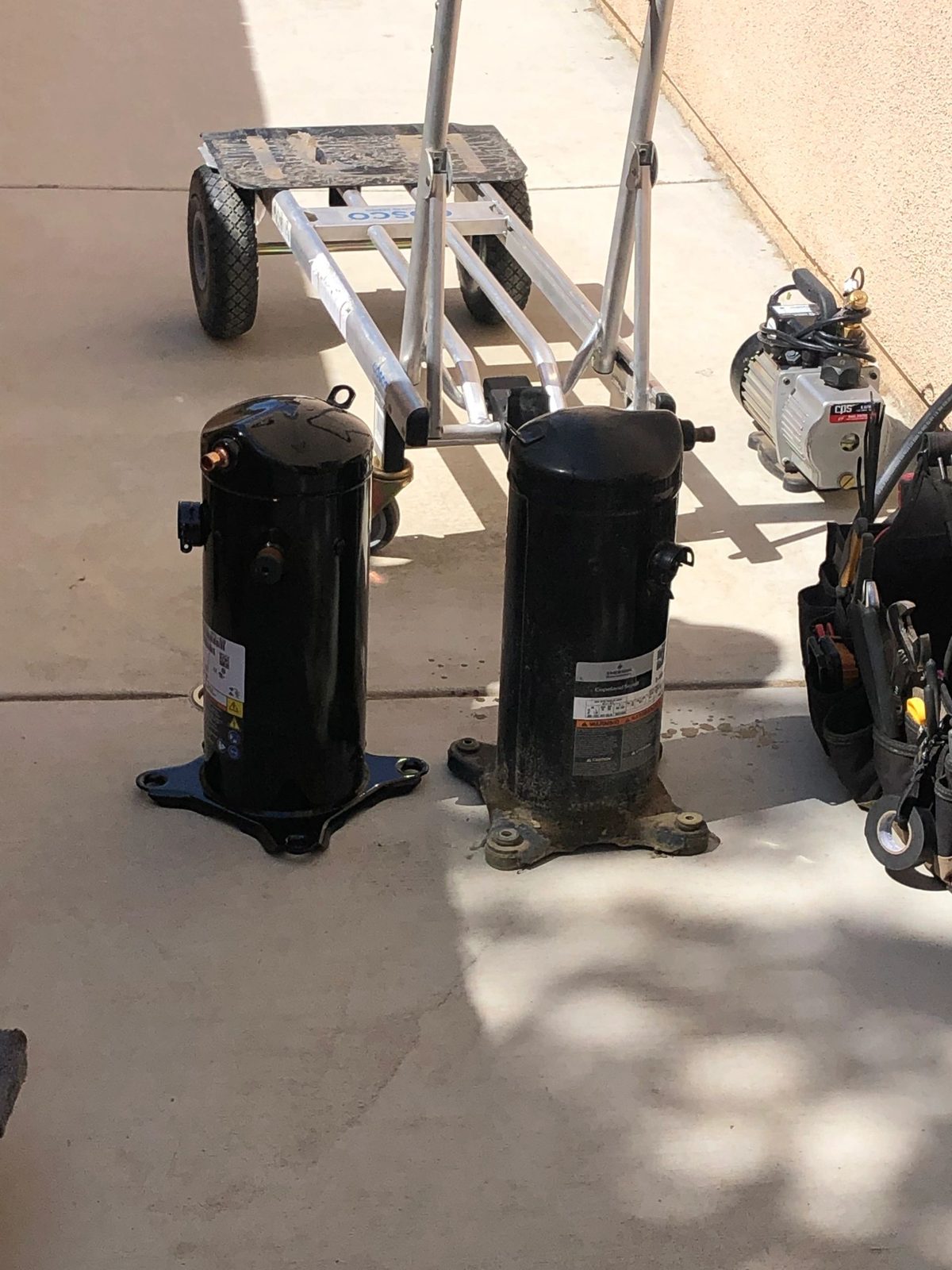 Technician replacing an AC compressor unit
