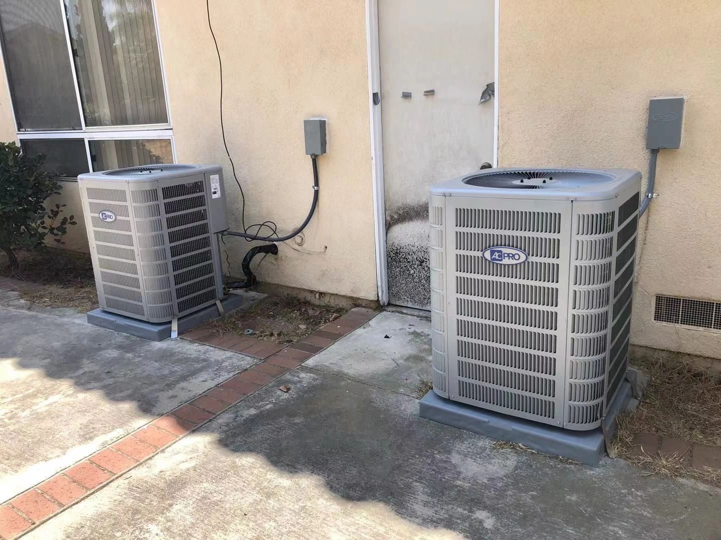 Twin HVAC systems installed side by side at a residential property